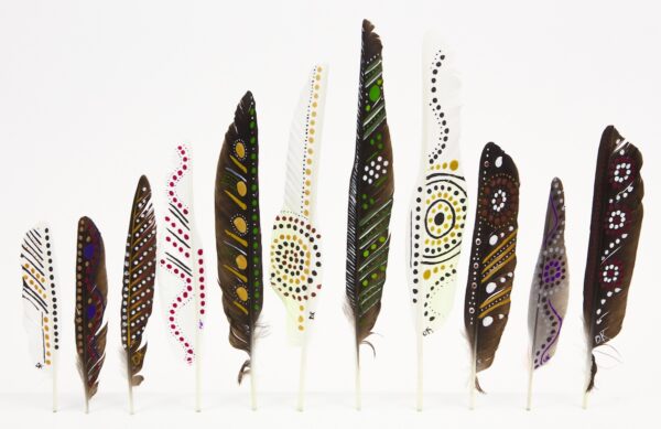 This artwork features a row of painted feathers, featuring vibrant patterns in white, brown, green, and purple against a plain background.